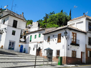 Fototapeta na wymiar Albaicin, Old muslim quarter, district of Granada in Spain. White houses street.