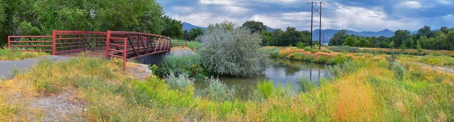 Views of Jordan River Trail Pedestrian and Train Track Bridge with surrounding trees, Russian...