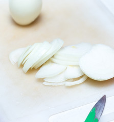 knife and chopped onion on a cutting board