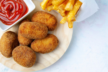 Upper of view of ham and chicken croquettes with chips and fried tomato