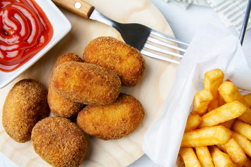 Upper of view of ham and chicken croquettes with chips and tomato