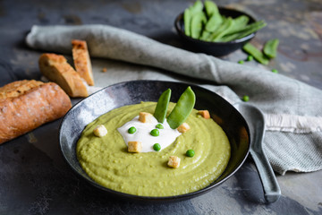 Creamy green pea soup with sour cream