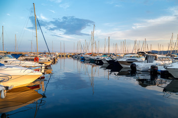 Yachts and boats in the harbor on sunset, reflection, beautiful coastal view, French Riviera. Holidays in France.