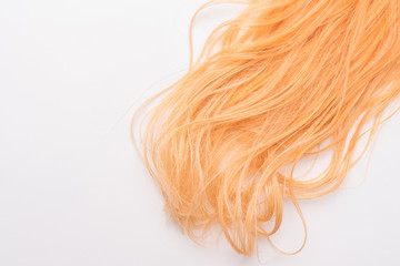 Human, natural honey-colored blond hair on white isolated background. Stylish, fashionable colors this year. Honey blonde shaken, wave and undulating hair. An example of hairstyle.