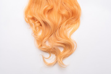 Human, natural honey-colored blond hair on white isolated background. Stylish, fashionable colors this year. Honey blonde shaken, wave and undulating hair. An example of hairstyle.