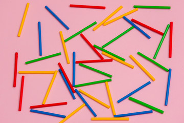 Colorful wooden sticks against pink background