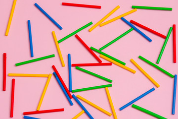Colorful wooden sticks against pink background