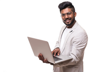 Portrit of a indian hipster man showing blank laptop computer screen over gray background