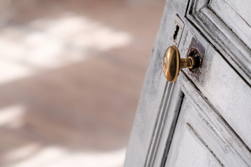 Pretty antique style white door with a golden handle