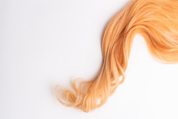 Human, natural honey-colored blond hair on white isolated background. Stylish, fashionable colors this year. Honey blonde shaken, wave and undulating hair. An example of hairstyle.