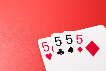 four five playing cards on a red background