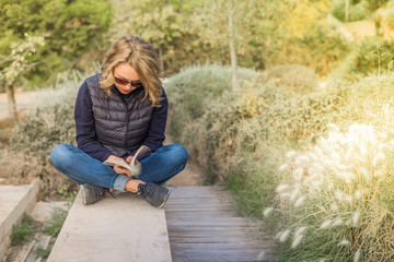 Stylish young woman outside the home reading a book