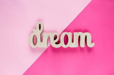 Wooden word Dream on pink viole  background. Summer, vacation, holidays concept. 