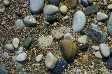 pebble stones on the sea beach, the rolling waves of the sea with foam