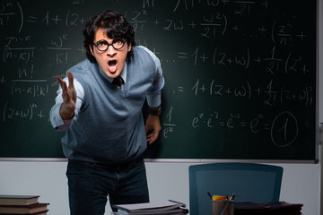 Young math teacher in front of chalkboard