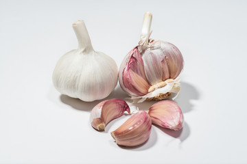 A head of fresh garlic with cloves isolated on a white background. The most popular addition to dishes. An aromatic ingredient of meals. Natural healing properties.