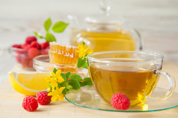 Herbal tea served with honey, fresh raspberries and lemon