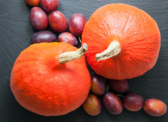 Ripe pumpkins and  plums on a slate board