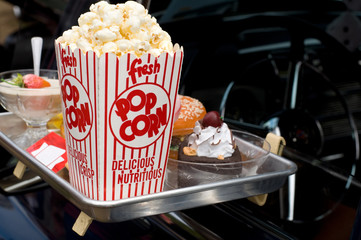 Imitation of Food and Popcorn in a Food Drive-Thru with Antique Car
