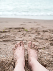 Woman's feet on sand near the sea