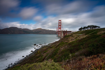 Fototapeta na wymiar Golden Gate bridge long exposure from west side featuring clouds and the ocean of the bay 