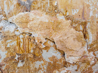 Natural stone texture. Yellow and red colorful background, flaky limestone rocky texture closeup