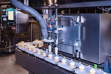 Ice cream making. Shop freezing. Conveyor in the refrigerator. Food industry. Ice cream production line. Converter. Ice cream in a cup. Frost.