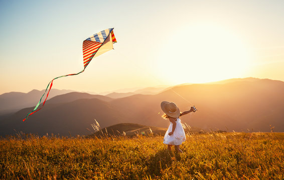 Happy Child Girl Running With Kite At Sunset Outdoors