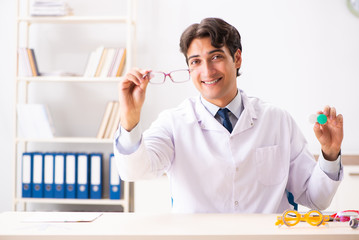 Young handsome doctor oculist working at the clinic 