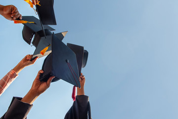 Black hat of the graduates floating in the sky.