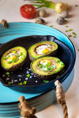 Avocado baked with quail eggs, fresh onion