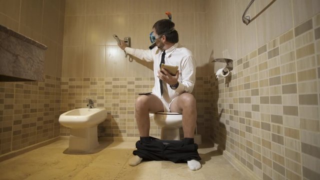 Businessman in diving mask working in the restroom