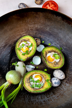 Avocado baked with quail eggs, fresh onion