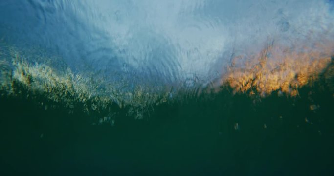 Beautiful golden sunset into the ocean, over under split view from in the water, abstract nature landscape