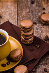 Dark Chocolate Macaron with Coffee Beans on Wooden Table. Selective focus. 