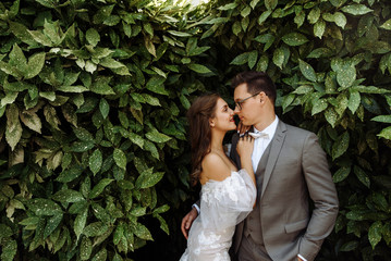 Wedding day. Beautiful bride and groom in wedding attires are hugging against the background of...