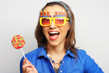 woman wearing big sunglasses holding lollipop