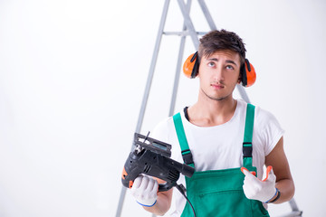 Young worker with earmuffs in noise cancelling concept 