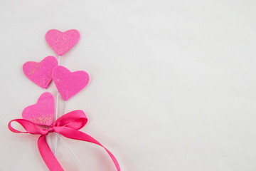 Valentines day decorative background with decorative pink hearts  with decorative ribbon on a white background. Close up. Top view.