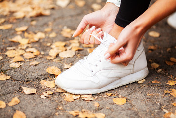 Fitness. Female runner tying her shoes preparing for a jog