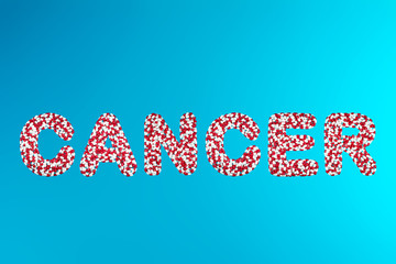inscription cancer white and red pills on a blue background top view. concept of medication and pharmaceuticals treatment of cancer