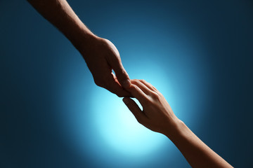 Man and woman holding hands on color background, closeup. Help and support concept