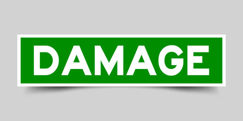 Square green color sticker with word damage on gray background
