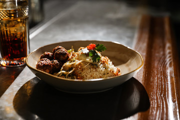 Plate with rice and meat balls served on table