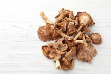 Dried mushrooms on wooden background, top view. Space for text
