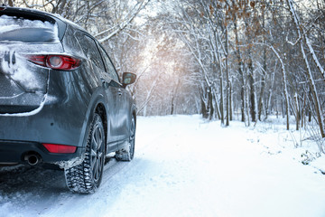Snowy country road with car on winter day. Space for text