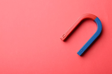 Red and blue horseshoe magnet on color background, top view with space for text