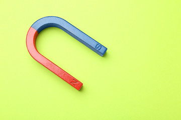 Red and blue horseshoe magnet on color background, top view with space for text