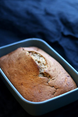 Homemade baked banana bread on a dark blue tablecloth. Selective focus.