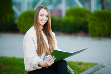 Obraz premium Successful and satisfied businesswoman, holding a documents ,looking at camera